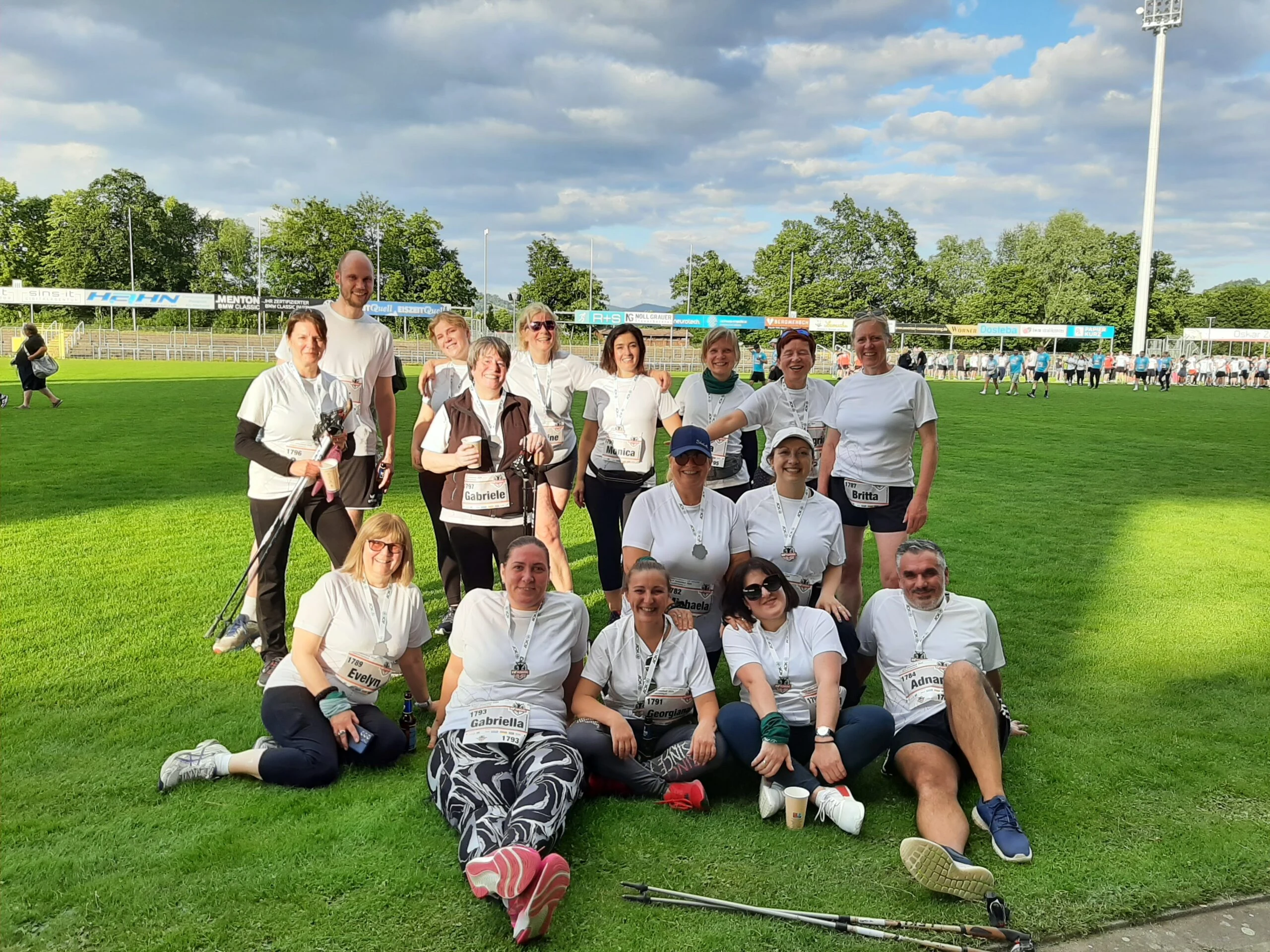 Eine Gruppe mit Startnummern und Medaillen auf dem Rasen eines Stadions